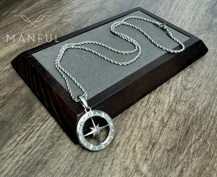 North Star Compass Pendant Necklace Silver, draped over a dark wooden display block