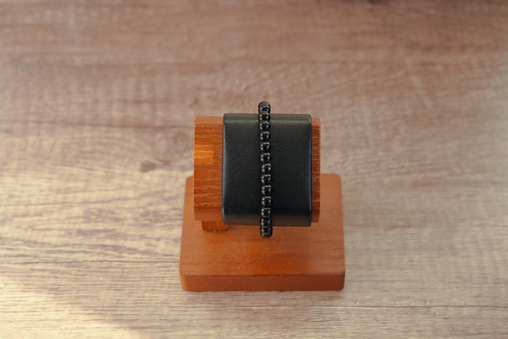 Onyx Bead Bracelet, displayed stretched over a wooden bracelet stand