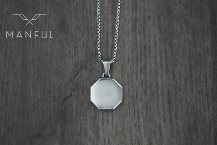 Onyx Octagon Necklace Silver, flat lay on a wood surface showing the plain silver reverse