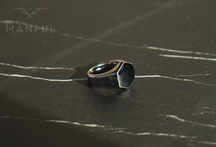 Onyx Silver Hexagon Signet Ring, standing on dark marble with pale veining
