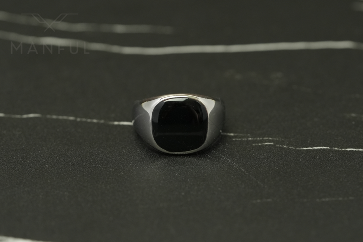 Onyx Signet Ring Silver, pulled back on dark marble facing the camera