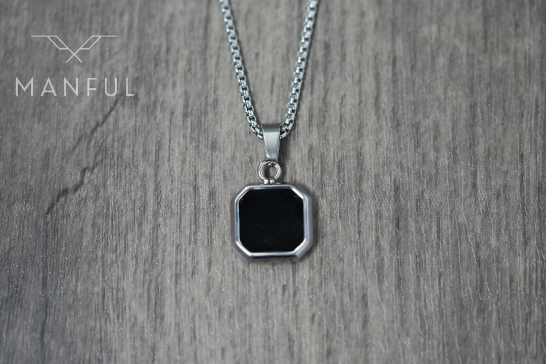 Onyx Square Necklace Silver, pendant laid flat on a wood surface