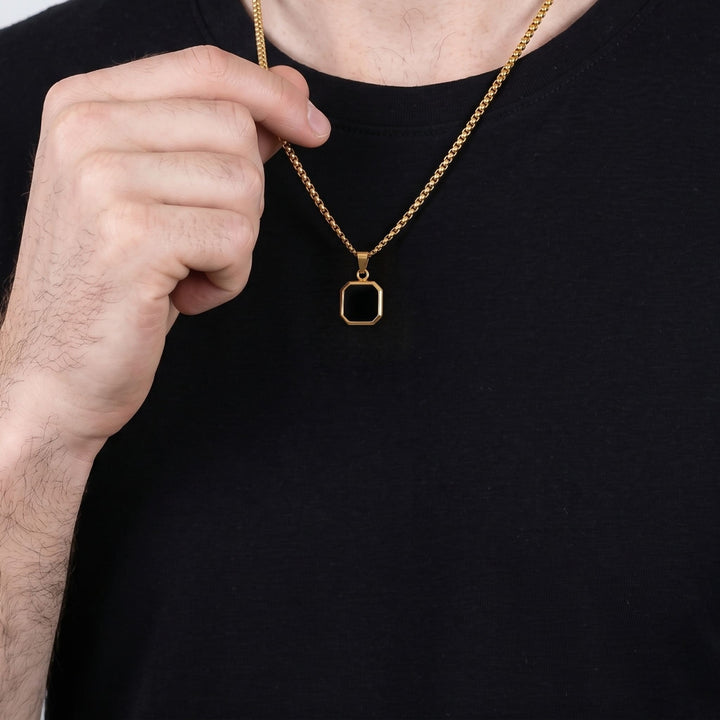 Onyx Square Necklace (Gold) on a man's chest as he holds the chain near his collar