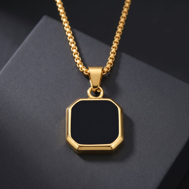 Onyx Square Necklace (Gold) resting on a dark charcoal block