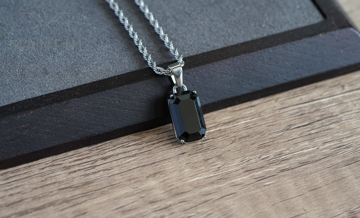 Onyx Stone Pendant Silver, resting at an angle on a wooden tray with a grey suede insert