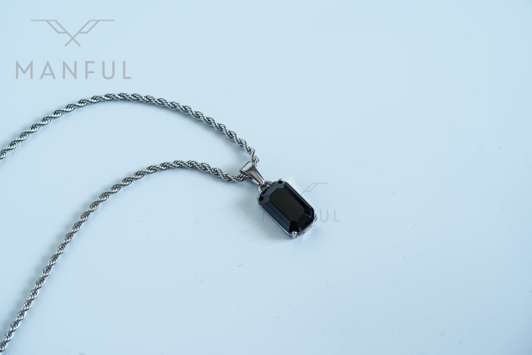 Onyx Stone Pendant Silver, laid flat on a pale surface with the full chain curved beside it