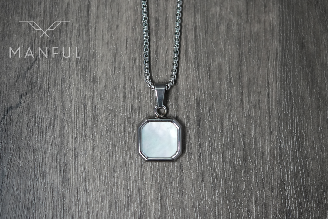 Pearl Square Necklace, pendant hanging straight down in a flat lay on a wood surface
