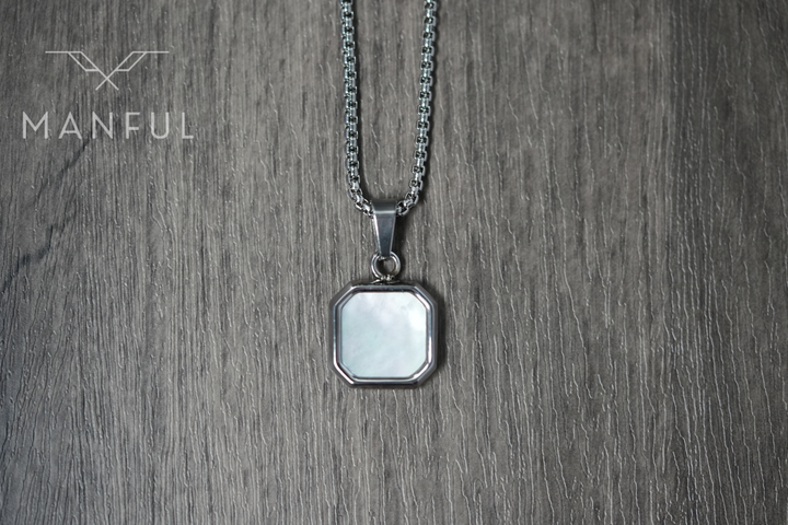 Pearl Square Necklace, pendant hanging straight down in a flat lay on a wood surface