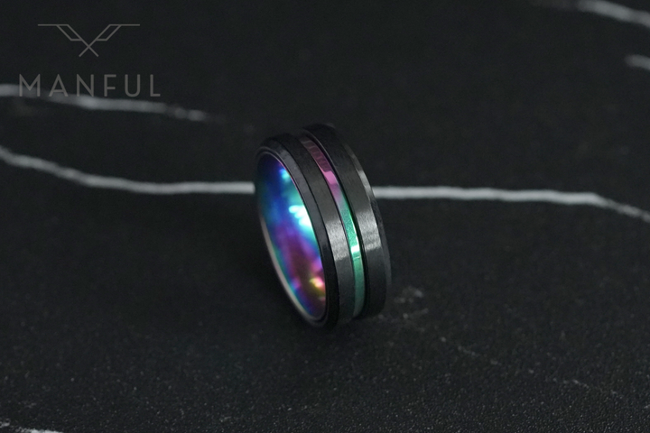 Rainbow Band, angled close up on dark marble with a pale vein streak above