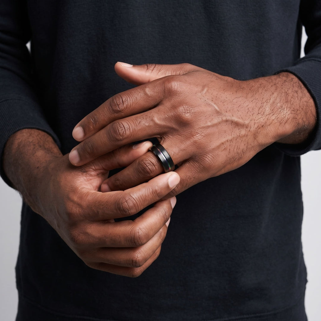 Rainbow Band on a man's finger as he turns it with his other hand