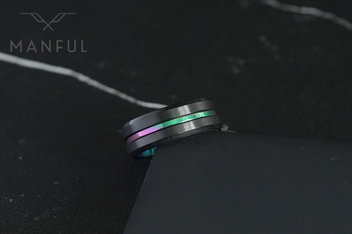 Rainbow Band, propped against the corner of a dark card on marble