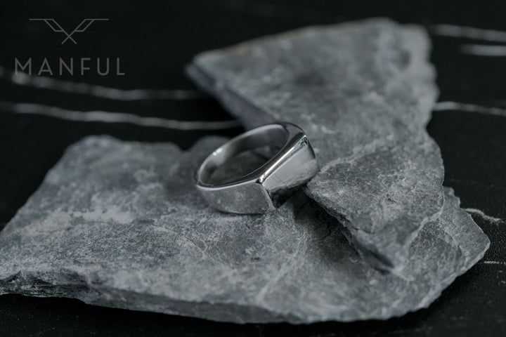 Rectangular Signet Ring Silver, propped upright on a broken piece of grey slate