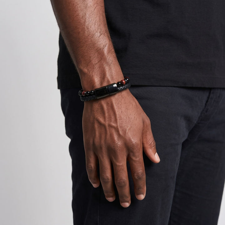 Red Tigers Eye Bead And Leather Bracelet on a man's wrist, his arm relaxed at his side