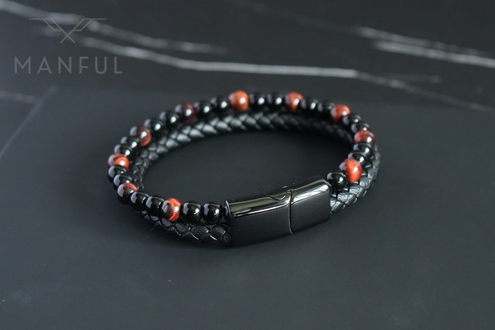 Red Tigers Eye Bead And Leather Bracelet, viewed from above on a dark surface showing the full loop