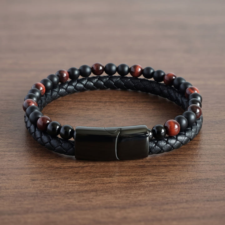Red Tigers Eye Bead And Leather Bracelet lying on a walnut table with the clasp at the front