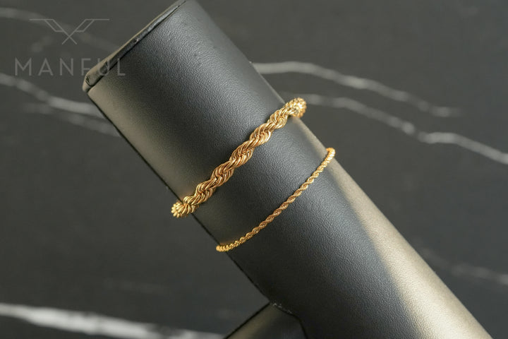 Rope Chain Bracelet Gold, draped over a black stand beside a thinner rope bracelet