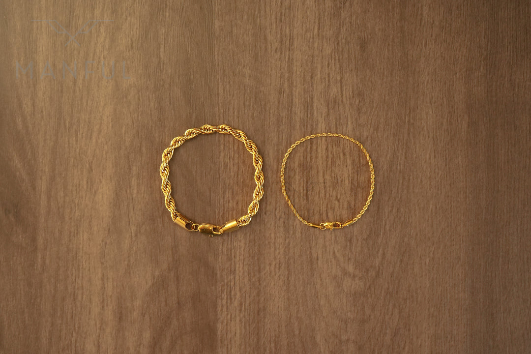 Rope Chain Bracelet Gold, laid in a circle on a wood surface beside a thinner rope bracelet