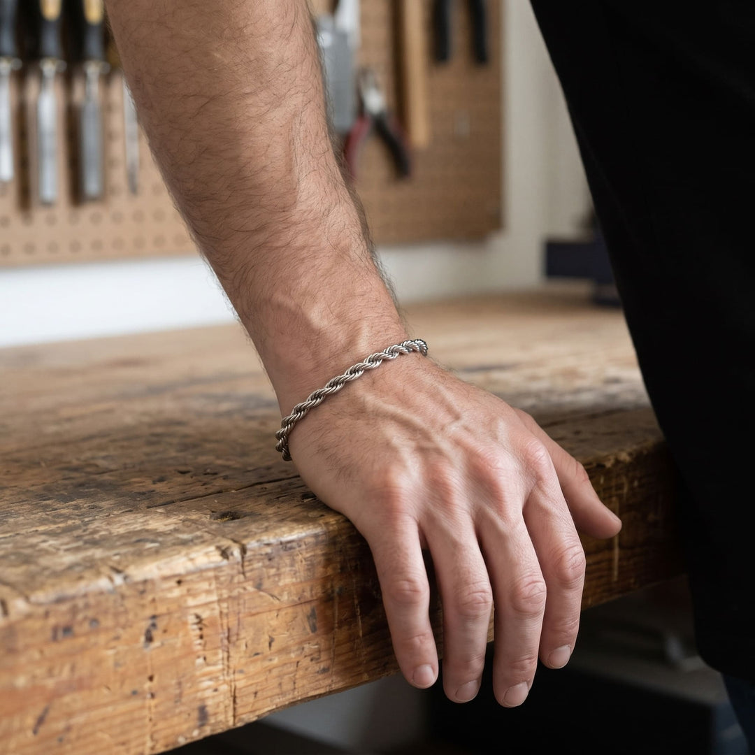 Rope Chain Bracelet (Silver) on a man's wrist, his hand resting on a workbench