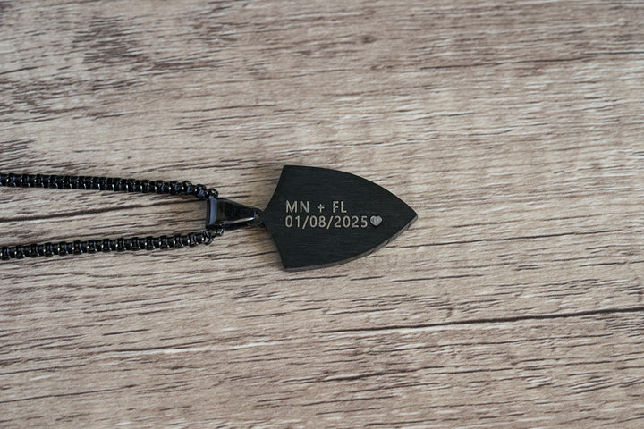 Shield Cross Pendant Black, close-up of the smooth back engraved with a name and date