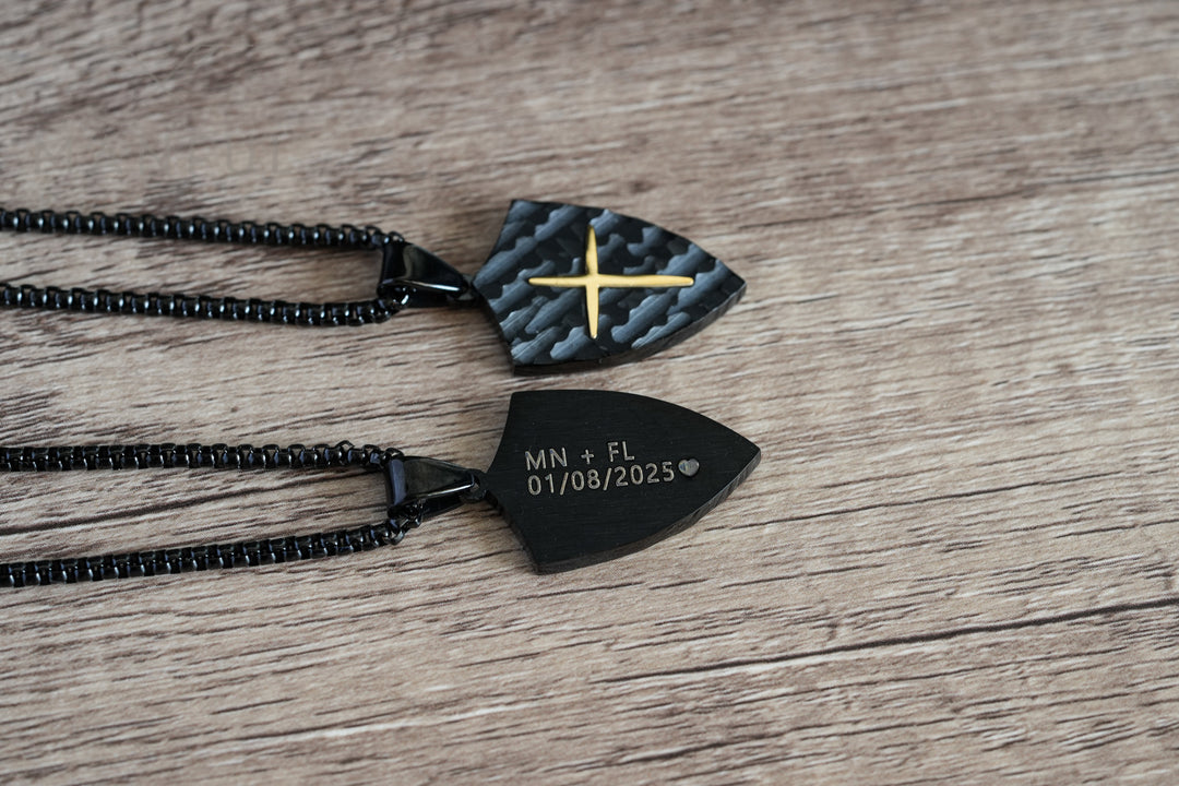 Shield Cross Pendant Black, close-up of two pendants side by side showing the cross front and engraved back