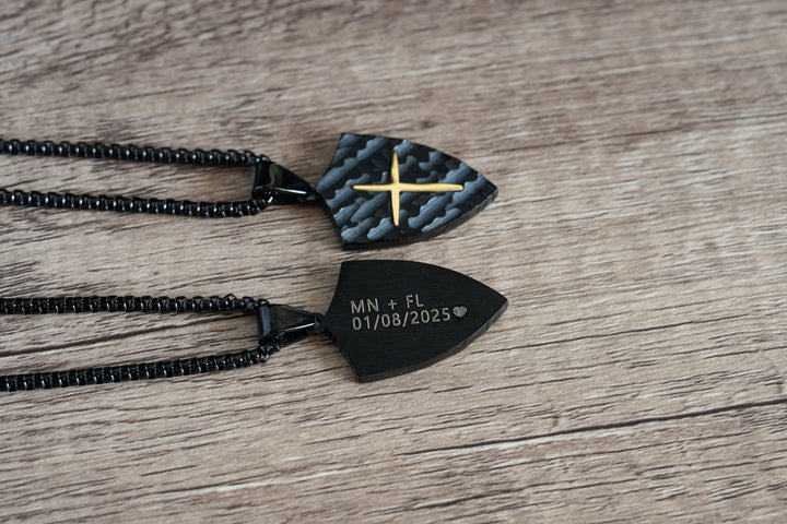 Shield Cross Pendant Black, close-up of two pendants side by side showing the cross front and engraved back