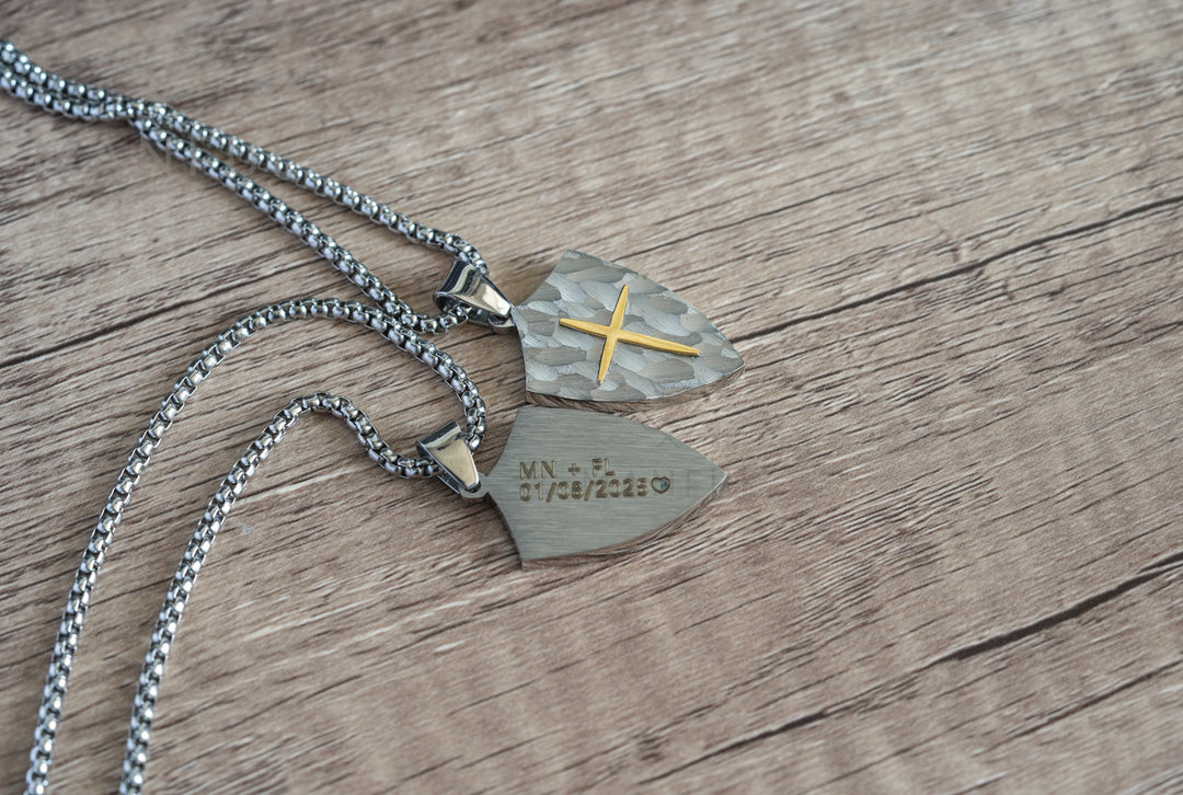 Shield Cross Pendant Silver, shown front and back together with both pendants overlapping on wood