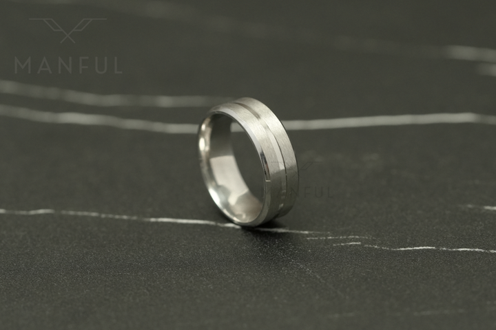 Silver Band, standing upright on a dark marble surface facing the camera