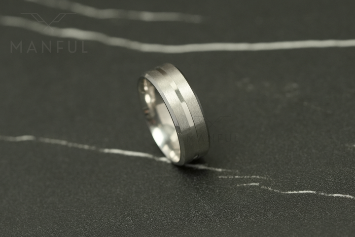 Silver Band, lying on its side on a dark marble surface in profile