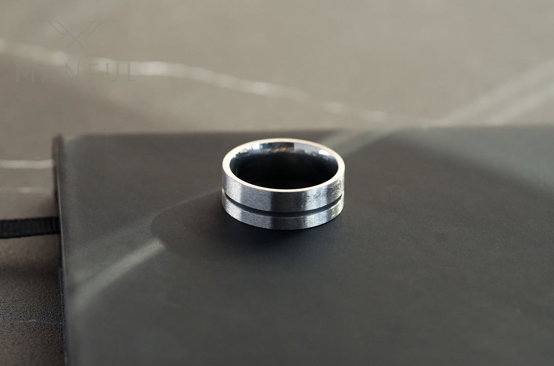 Off-balance Silver Band, resting on top of a black notebook