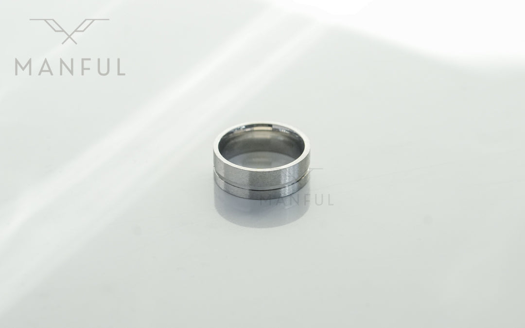 Off-balance Silver Band, lying flat on a glossy white surface with reflection