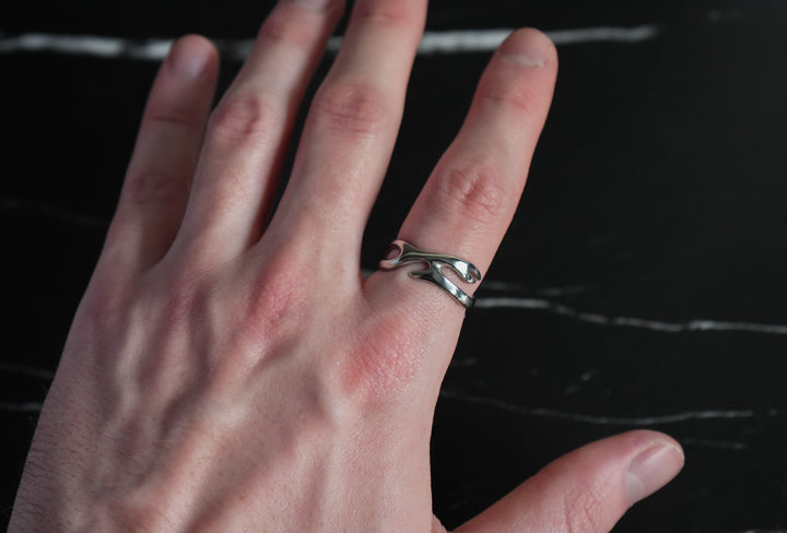 Silver Flame Ring, worn on a man's finger against a dark marble surface