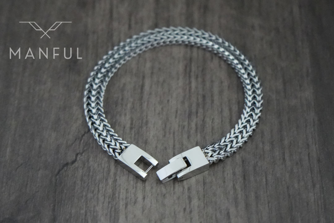 Foxtail Bracelet Silver, clasp open on a wood surface