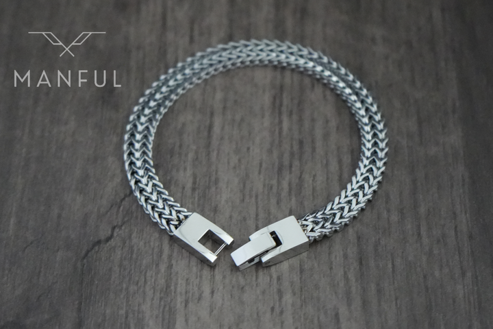 Foxtail Bracelet Silver, clasp open on a wood surface