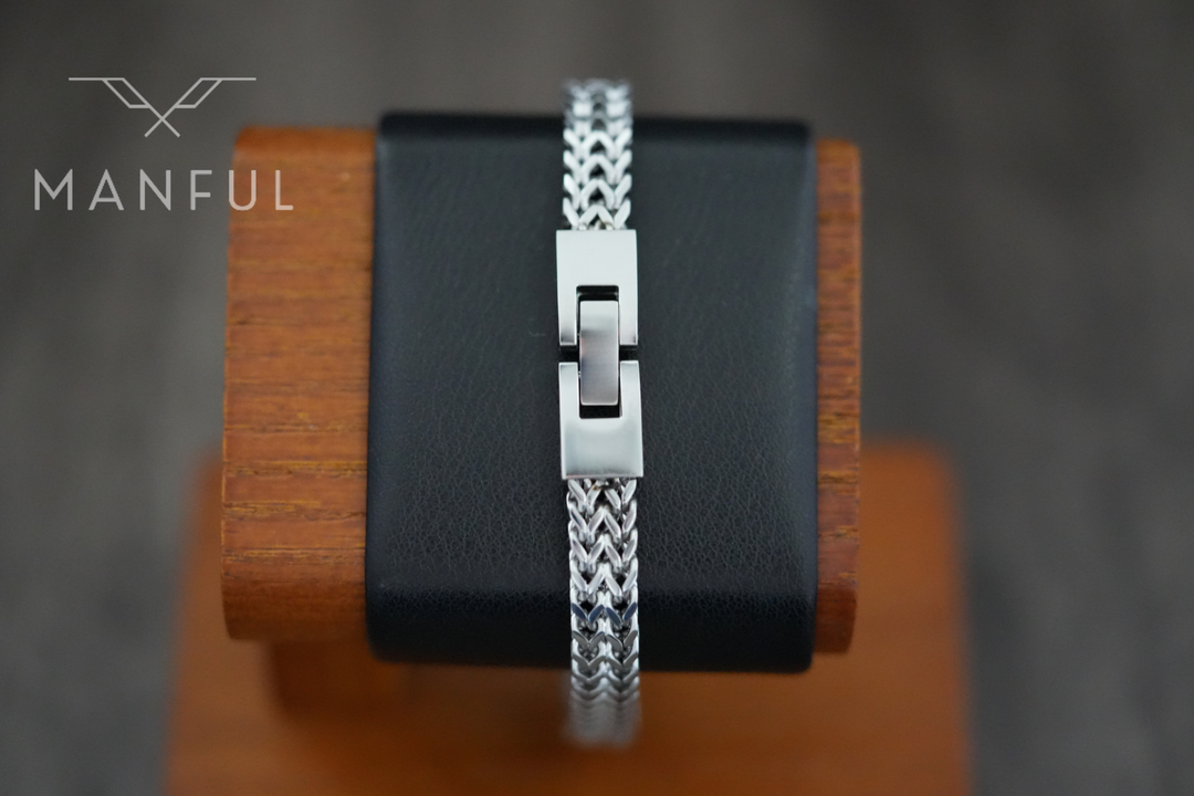 Foxtail Bracelet Silver, clasp closed draped over a wooden bracelet stand