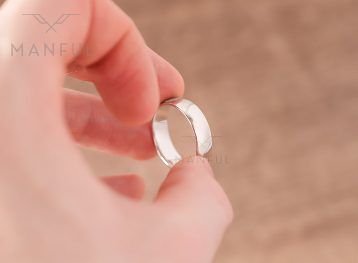 Simple 6mm 925 Silver Ring, held between a finger and thumb