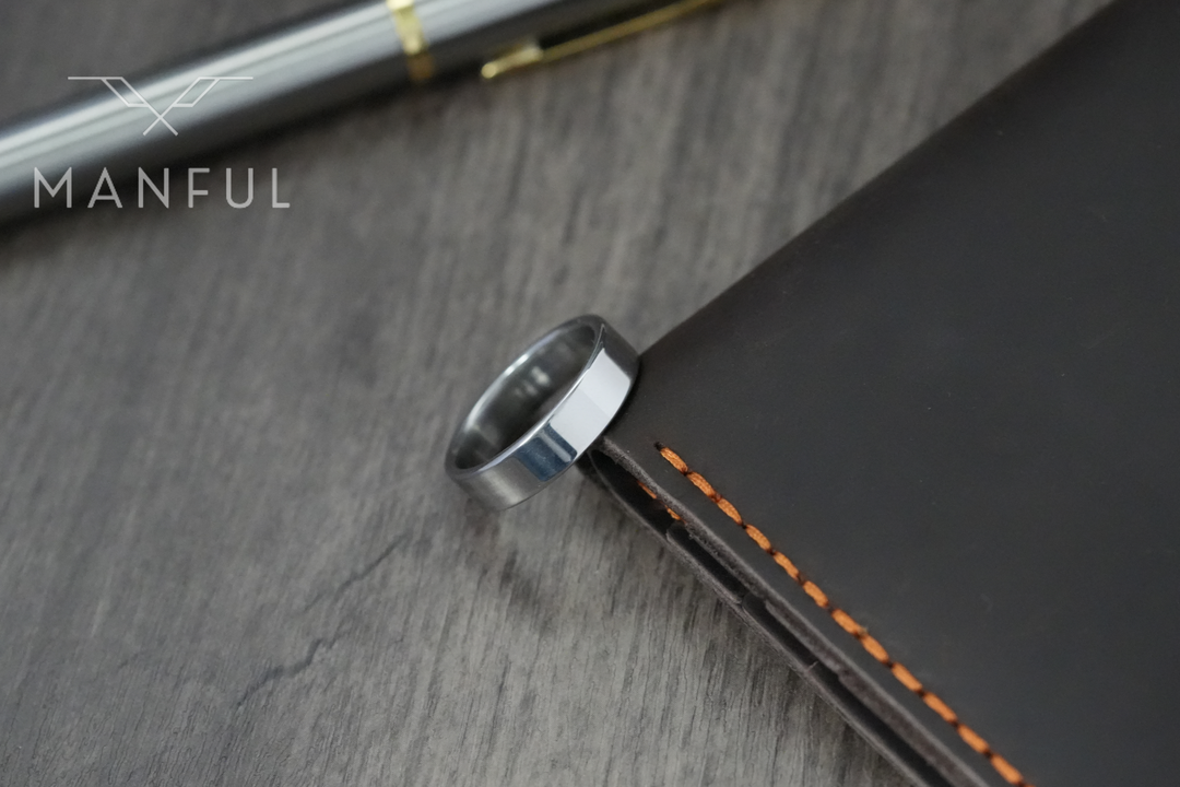 Simple 6mm Ring Silver, leaning against a leather notebook edge beside a fountain pen