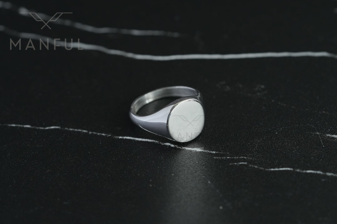 Classic Silver Signet Ring, front-facing on a dark marble surface