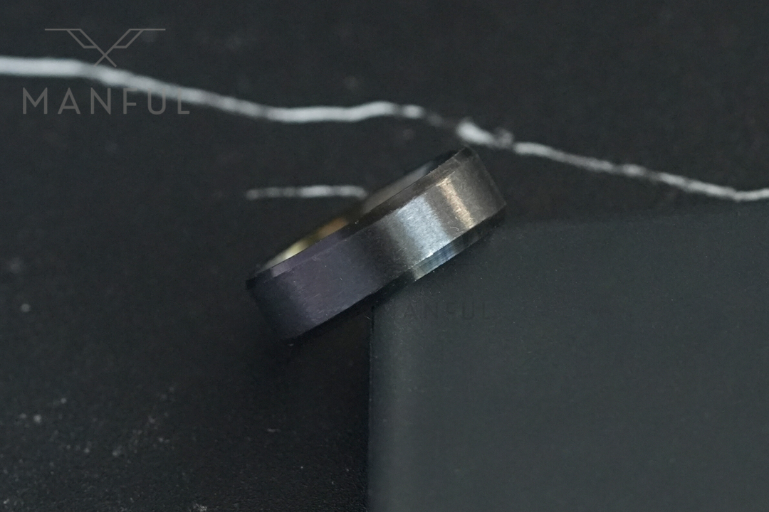 Simple Stainless Steel Ring 8mm Black, propped against the edge of a dark card on marble