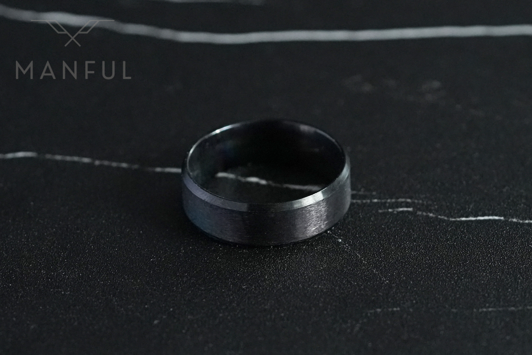 Simple Stainless Steel Ring 8mm Black, lying flat on dark marble seen from above