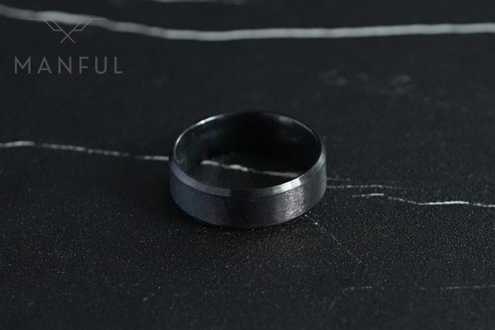 Simple Stainless Steel Ring 8mm Black, lying flat on dark marble seen from above