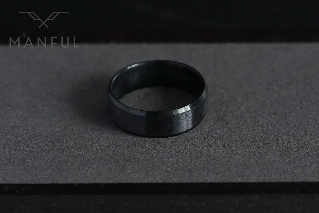 Simple Stainless Steel Ring 8mm Black, standing upright on a charcoal textured surface