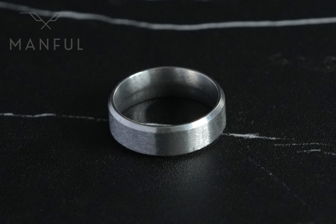 Simple Stainless Steel Ring 8mm Silver, lying flat on a dark veined marble surface