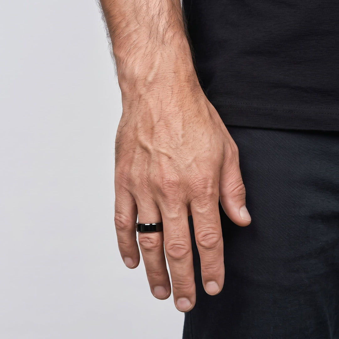 Simple 6mm Ring (Black) on a man's ring finger, his hand hanging at his side