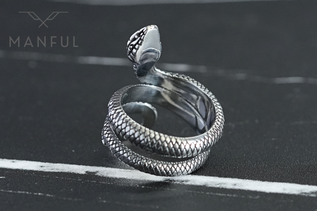 Snake Ring, tilted to show the coil from above on a dark marble surface