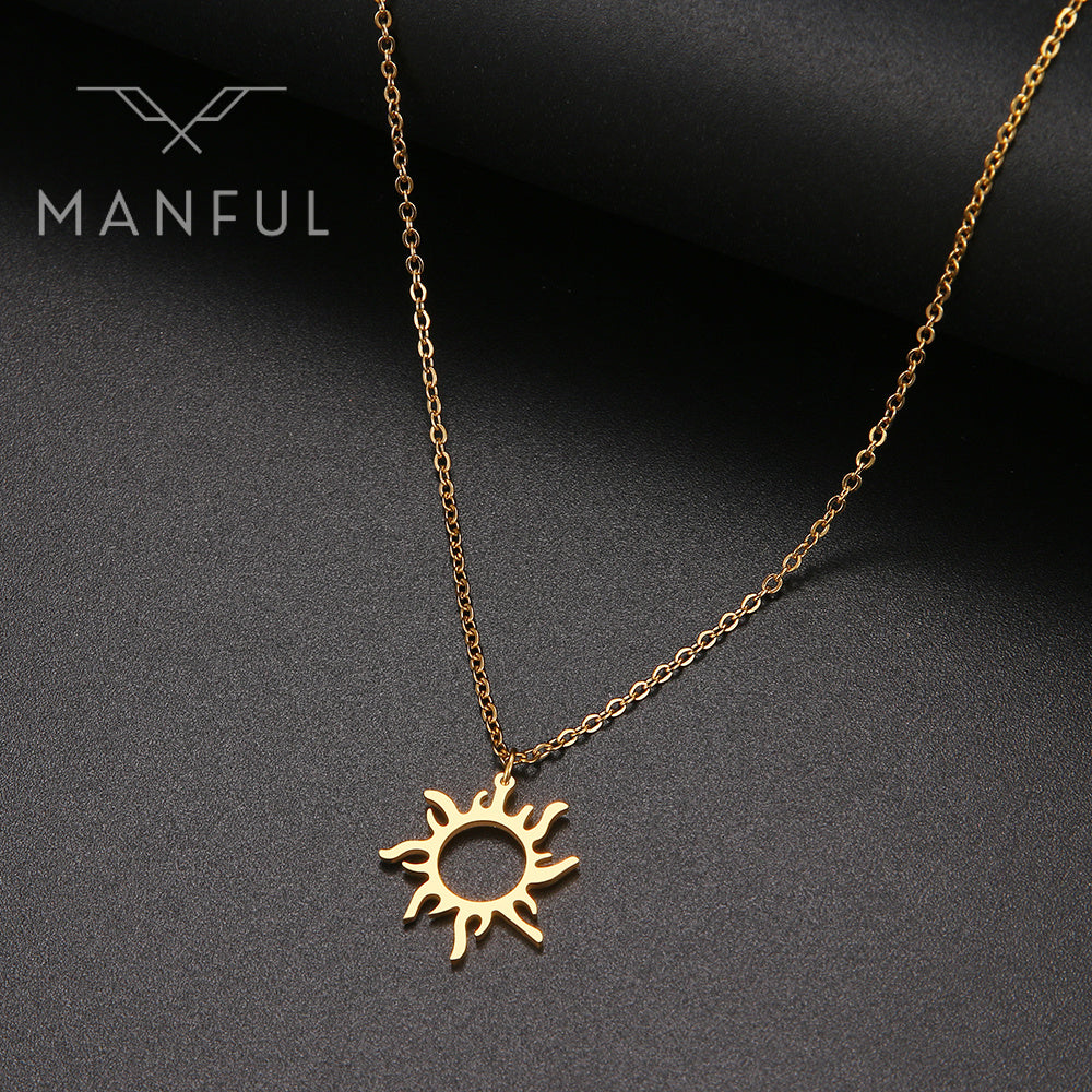 Sun Pendant Necklace Gold, hanging at an angle against a dark fabric background