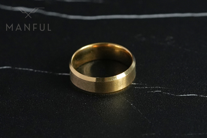 Simple Stainless Steel Ring 8mm Gold, facing the camera on a dark marble surface
