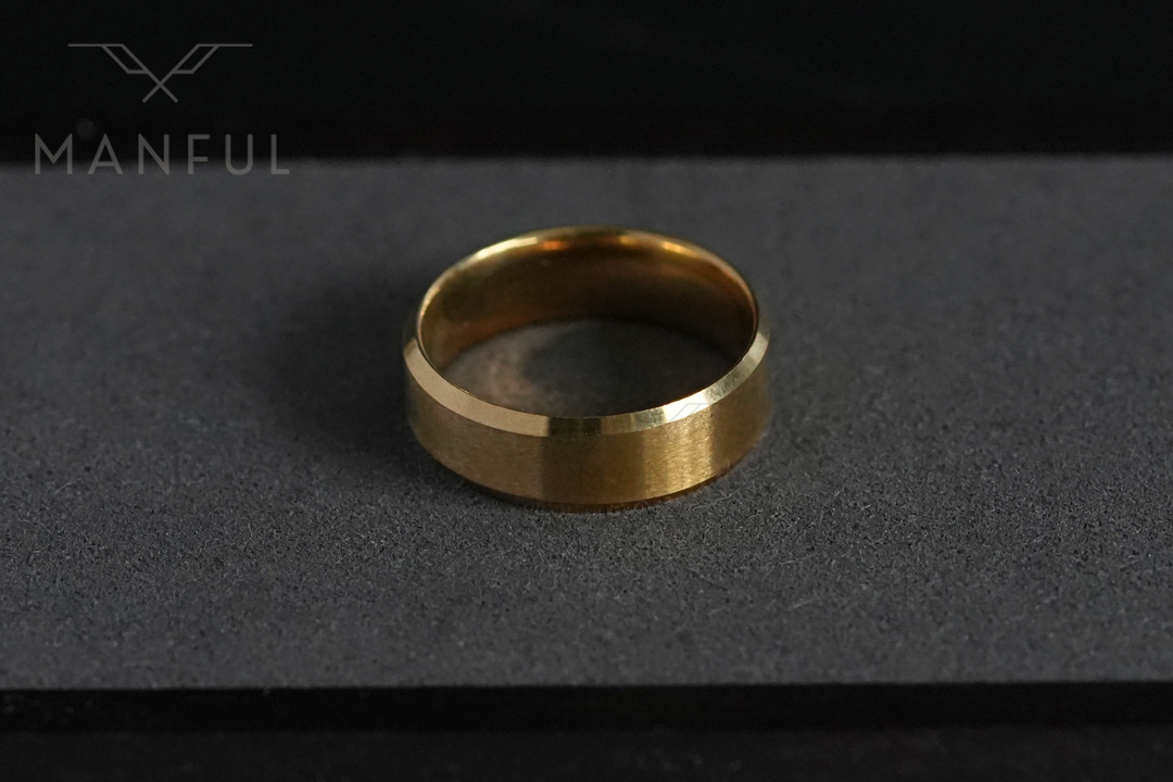 Simple Stainless Steel Ring 8mm Gold, resting on the grey foam lid of its gift box