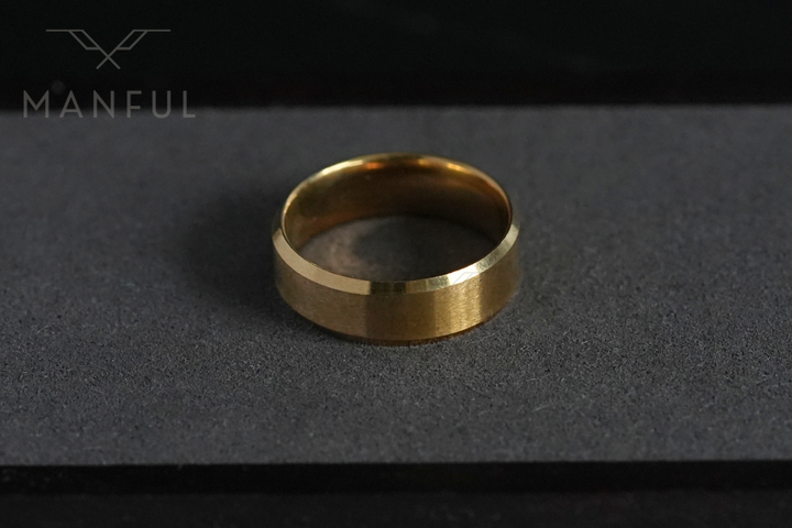 Simple Stainless Steel Ring 8mm Gold, resting on the grey foam lid of its gift box