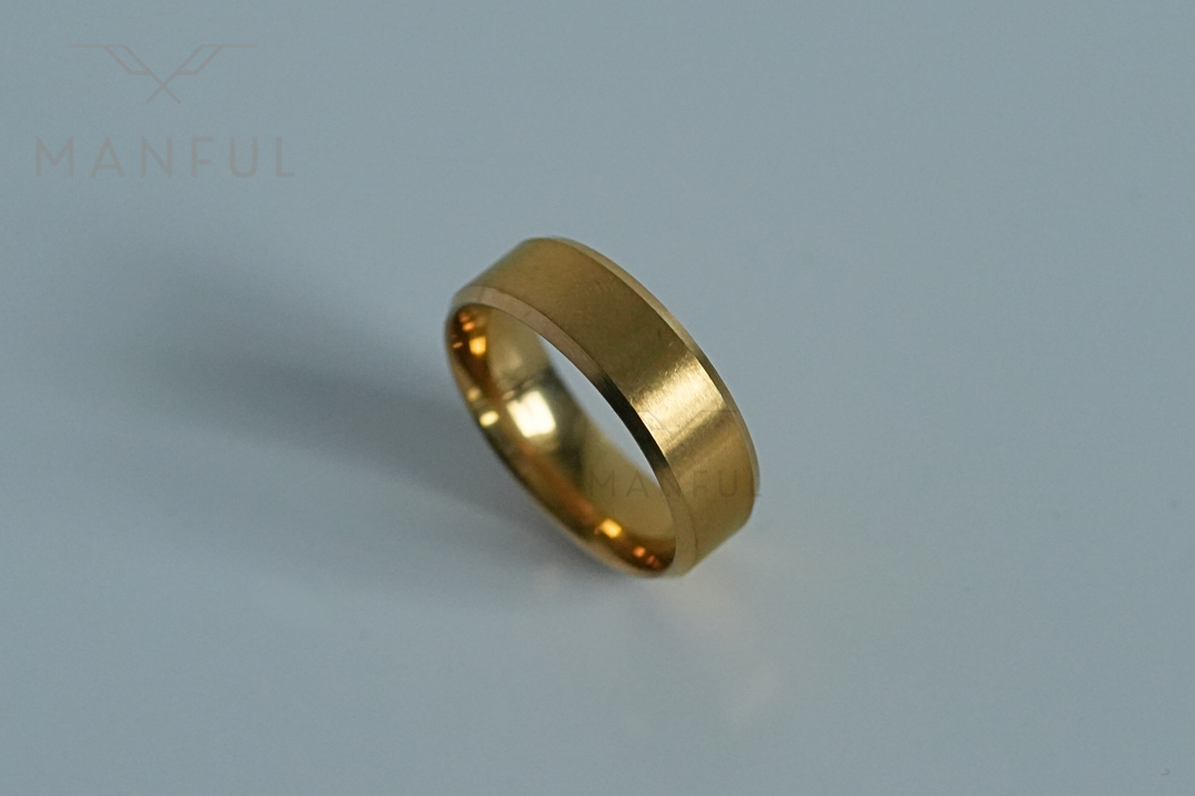 Simple Stainless Steel Ring 8mm Gold, angled on a plain light grey surface