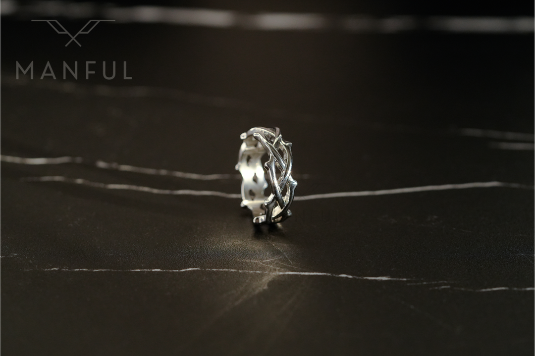 Thorn Ring Silver, standing upright on a dark marble surface in a close-up crop